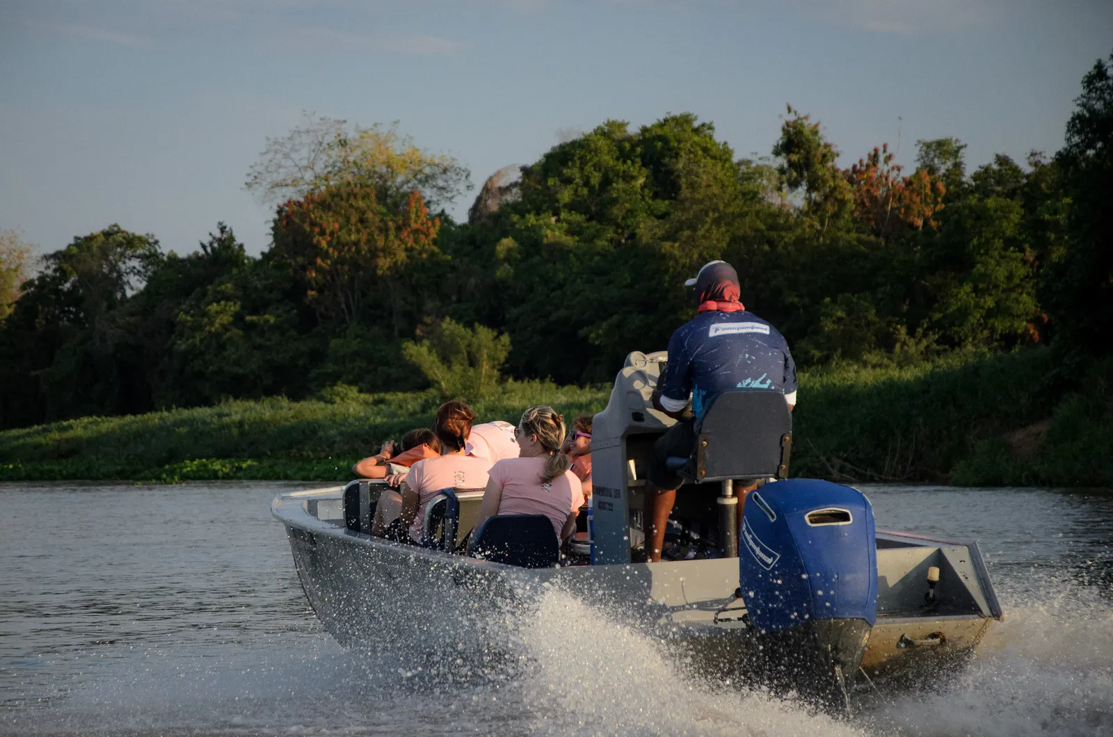 A group aboard a skiff cruising at dusk