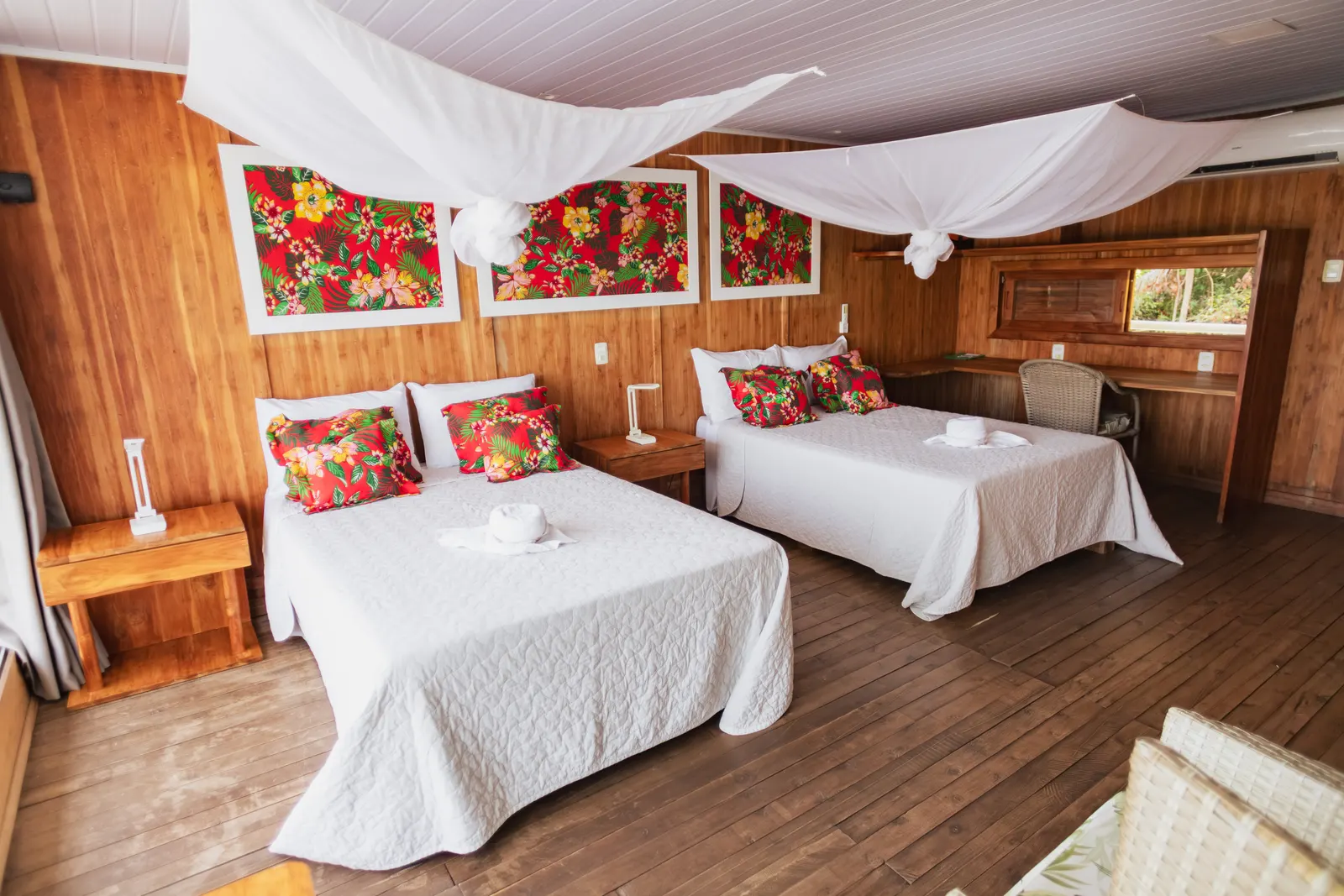 Suíte flutuante com camas, mosquiteiros e acabamento em madeira
