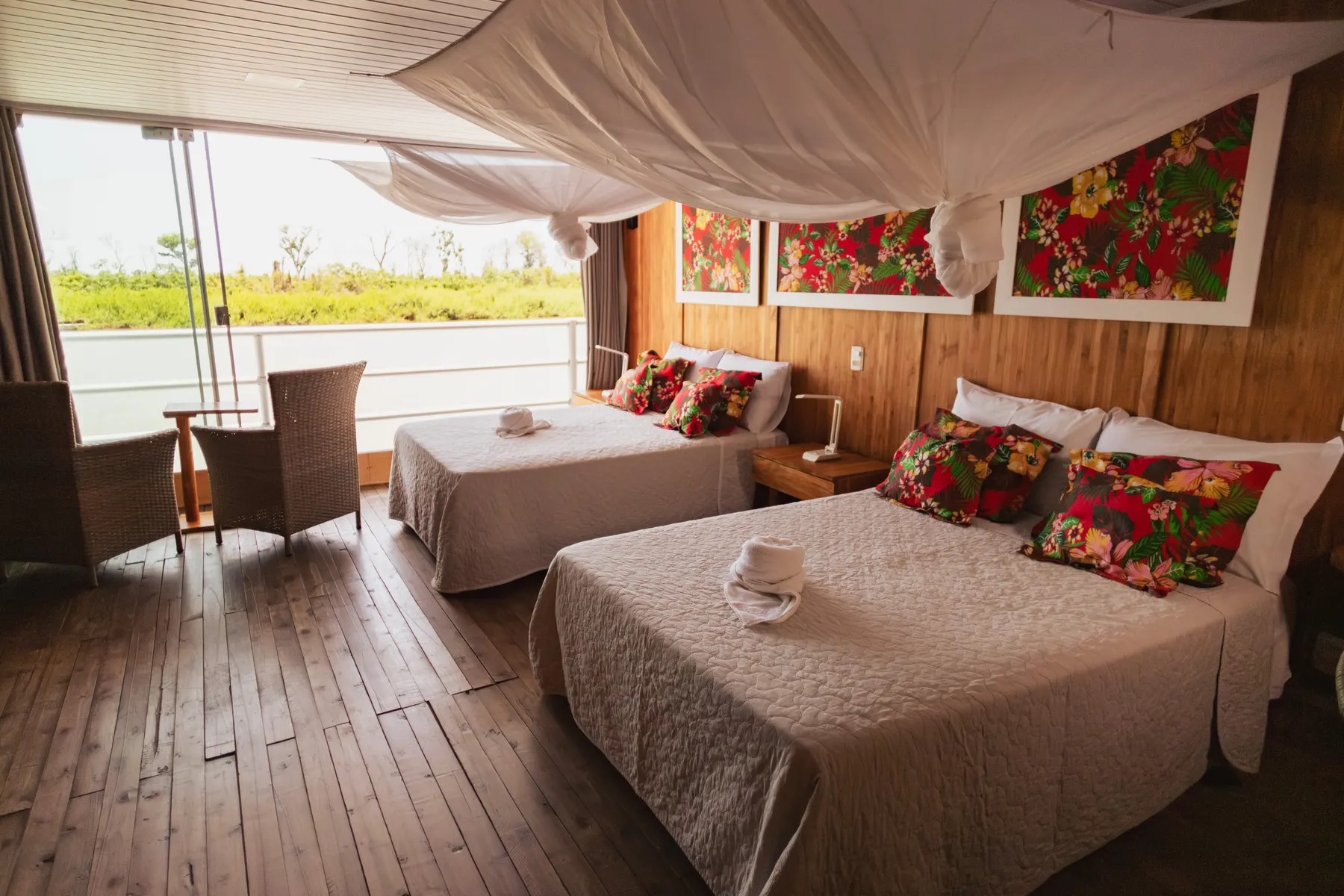 Suíte Jaguar com cama de casal e janela panorâmica aberta para o rio