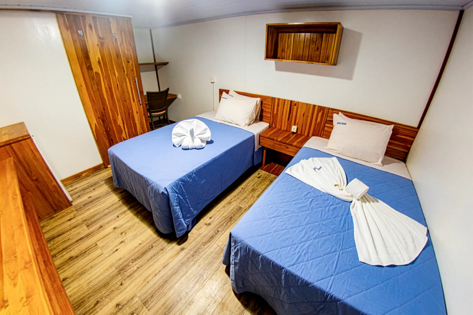 Cabine do Balsa Transpantanal, com duas camas e paredes de madeira
